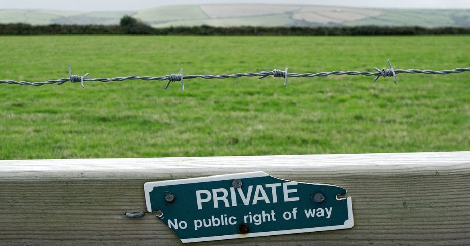 private signage and barbed wire fenced land